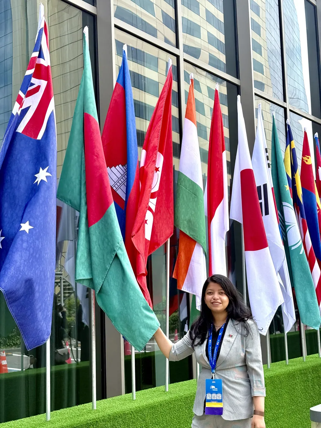 Afshana holding the Bangladesh flag in a row of Asia Pacific flags