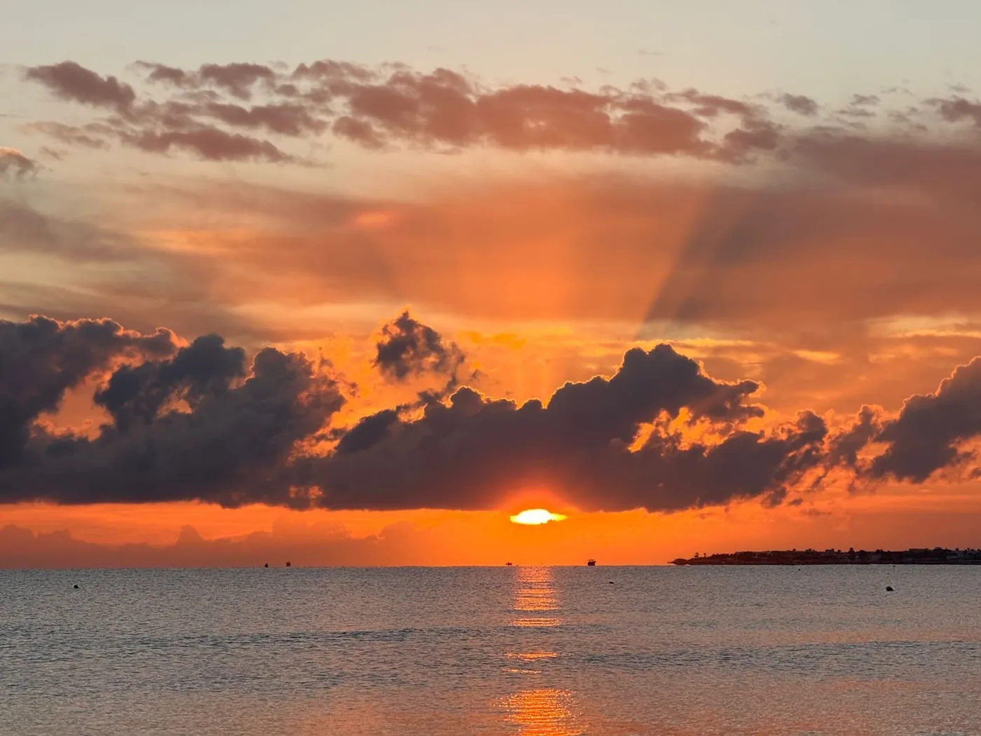 The sun sinking behind clouds over the Mediterranean