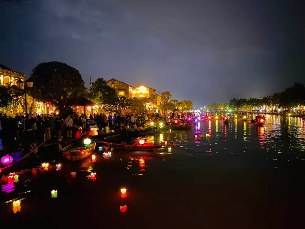 Floating lanterns drifting on a dark river in Hoi An