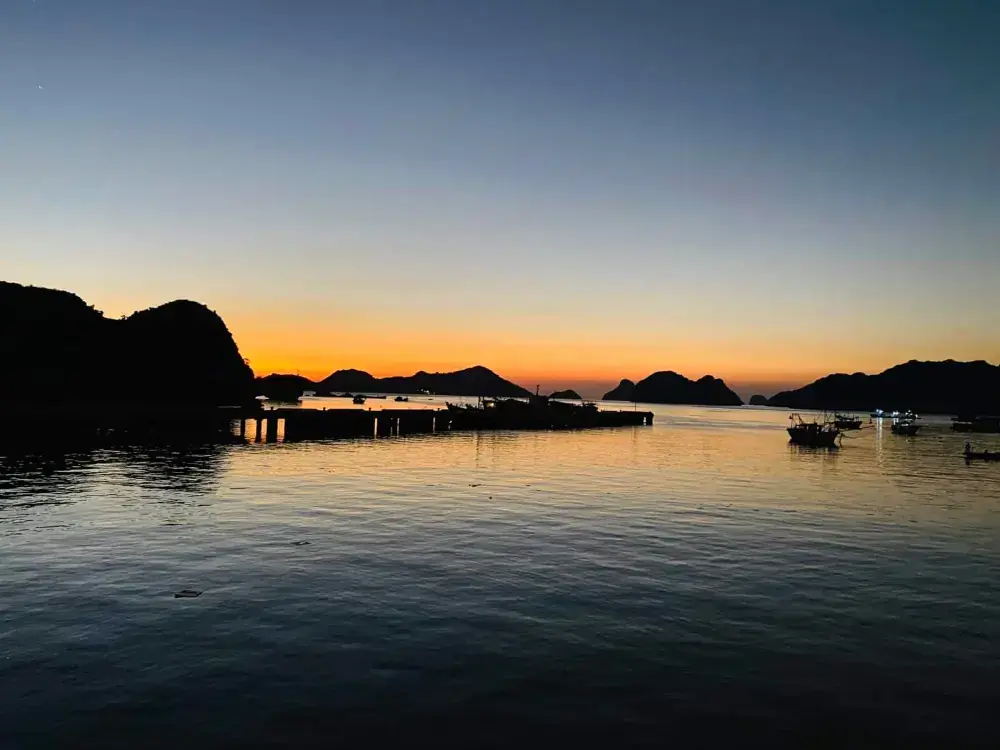 Limestone islands in silhouette against an orange sunset