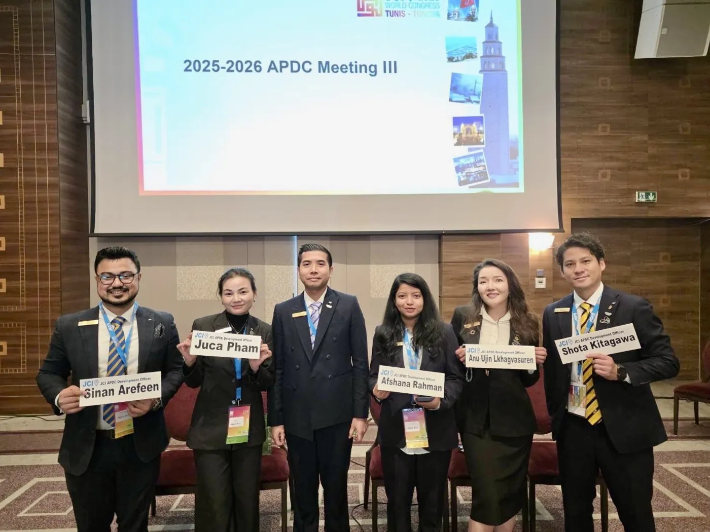 Afshana Diya with fellow JCI APDC Development Officers holding name cards in Tunis