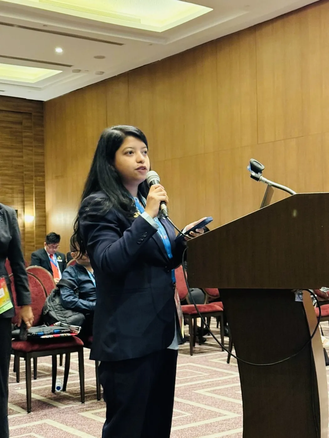 Afshana Diya speaking into a microphone at a JCI World Congress session